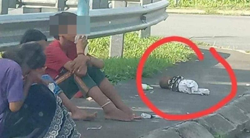 Netizen geram tengok bayi terbaring tepi jalan sambil ibu bapa ‘sedap’ hisap gam